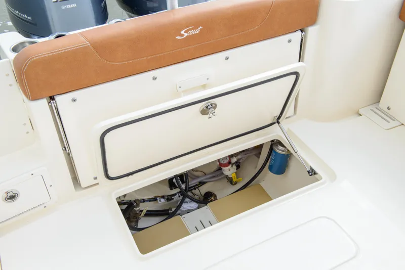 Slide: The Image of 2026 Scout 255 Dorado boat storage compartment with open hatch and visible equipment. - 27