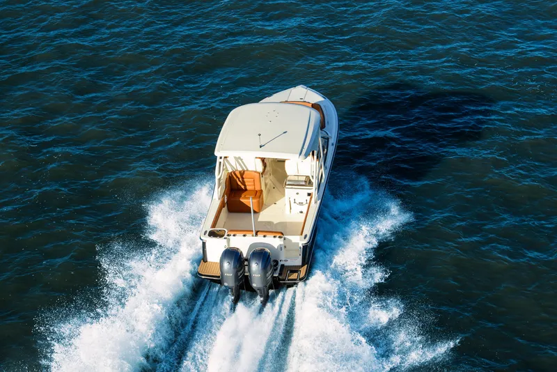 Slide: The Image of 2026 Scout 255 Dorado boat cruising on open water, rear view. - 3