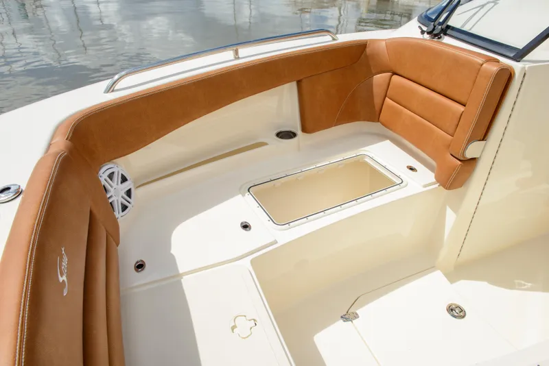 Slide: The Image of 2026 Scout 255 Dorado boat interior with tan seating and storage compartment. - 9