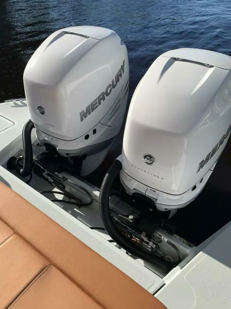Slide: The Image of Twin Mercury engines on 2023 Saxdor 320 GTO boat, docked on water. - 20
