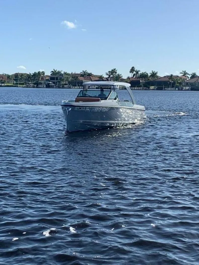 Slide: The Image of 2023 Saxdor 320 GTO cruising on a sunny lake with palm trees in the background. - 5
