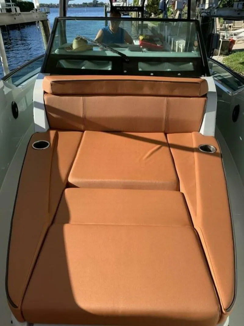Slide: The Image of 2023 Saxdor 320 GTO boat with tan seating, docked by the water. - 8