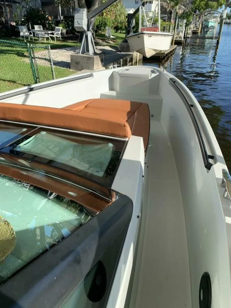 Slide: The Image of 2023 Saxdor 320 GTO boat docked by a waterfront, featuring sleek design and comfortable seating. - 9