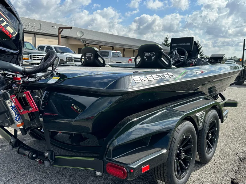 Slide: The Image of 2024 Skeeter FXR21 LE boat on trailer, parked outdoors under cloudy sky. - 11