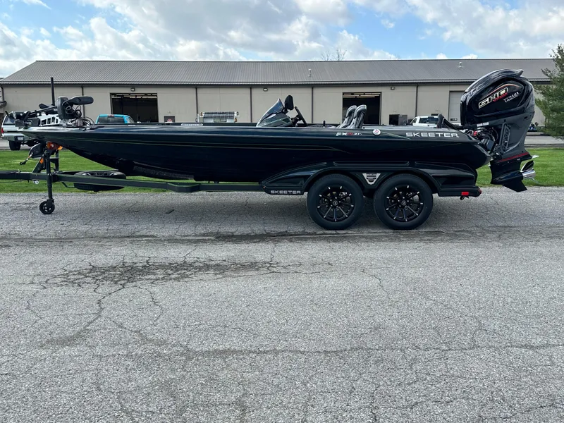 Slide: The Image of 2024 Skeeter FXR21 LE boat, black, parked on a trailer, outdoor setting. - 4