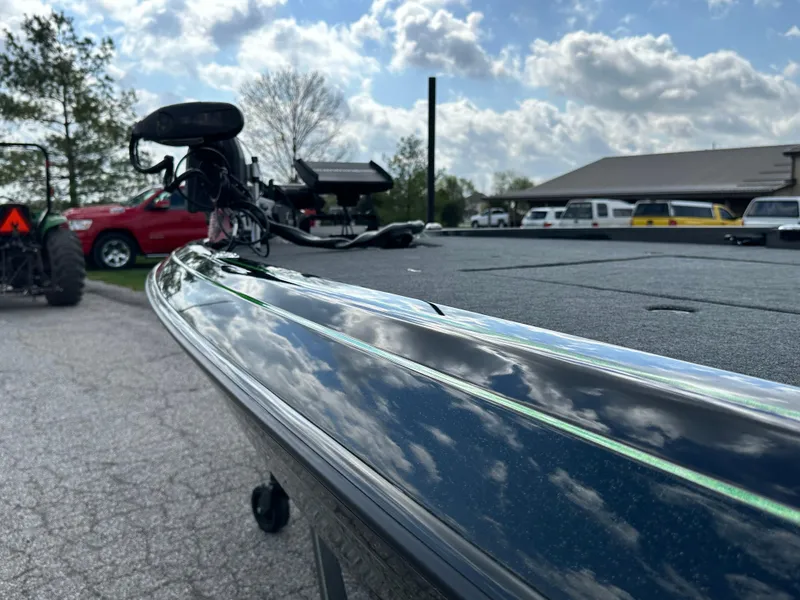Slide: The Image of 2024 Skeeter FXR21 LE boat reflecting cloudy sky in parking lot. - 8