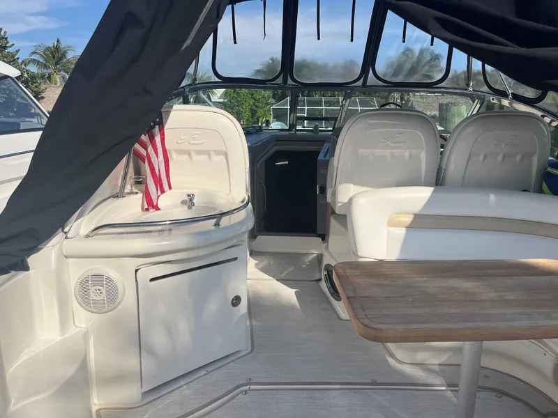 Slide: The Image of 2008 Sea Ray 340 Sundancer interior with seating, table, and American flag. - 14