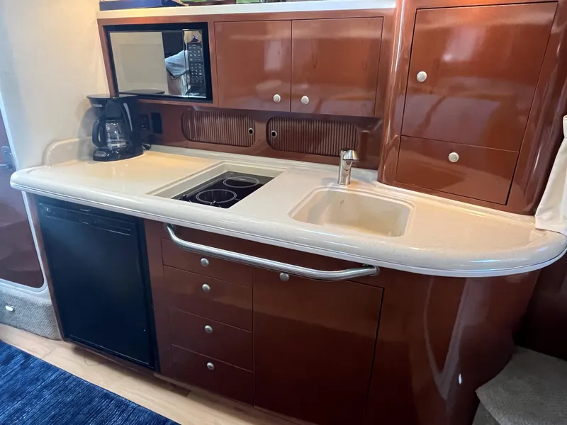 Slide: The Image of 2008 Sea Ray 340 Sundancer yacht kitchen with sink, stove, and cabinets. - 18