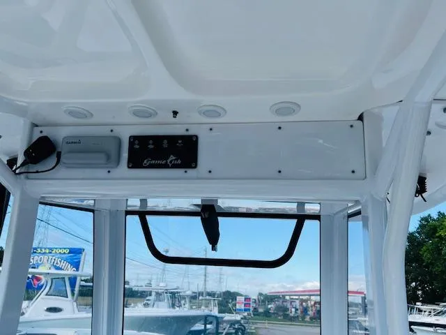 Slide: The Image of 2019 Sea Hunt Gamefish 27 boat speakers and rod holders under blue sky. - 10