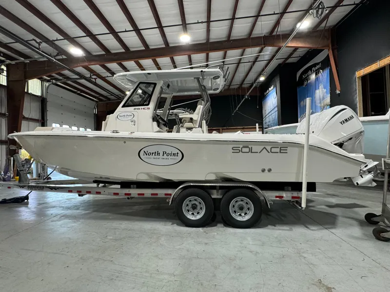 Slide: The Image of 2025 Solace 28 HCS boat on trailer in warehouse setting. - 14