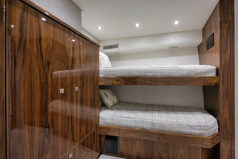 Slide: The Image of Luxurious 2019 Viking 80 Convertible yacht cabin with wooden bunk beds and modern lighting. - 39