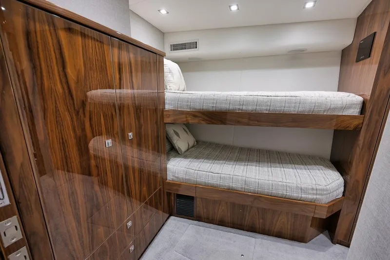 Slide: The Image of Interior of 2019 Viking 80 Convertible yacht with wooden bunk beds and modern lighting. - 40