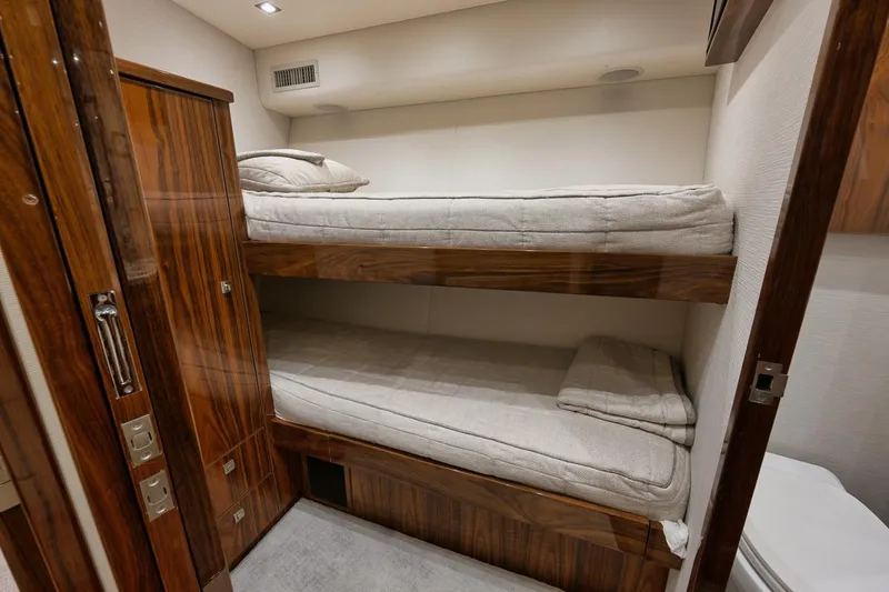 Slide: The Image of Bunk beds in 2019 Viking 80 Convertible yacht cabin with wooden accents. - 42