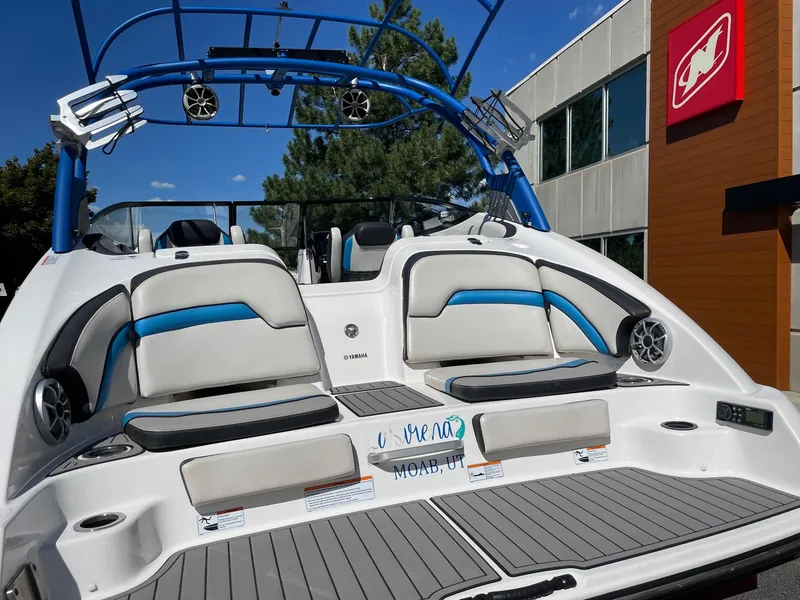 Slide: The Image of 2018 Yamaha Boats 242X E-Series with blue accents, docked near a modern building. - 3