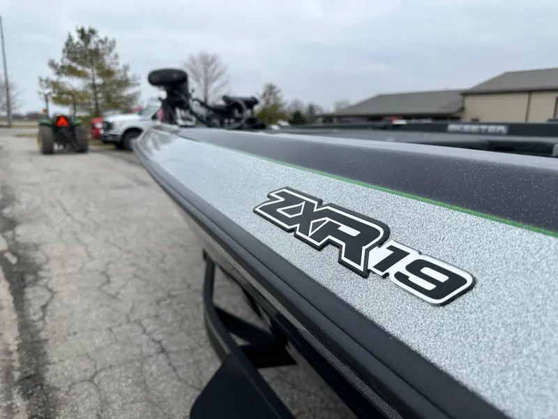 Slide: The Image of 2024 Skeeter ZXR19 boat parked outdoors on a cloudy day. - 14