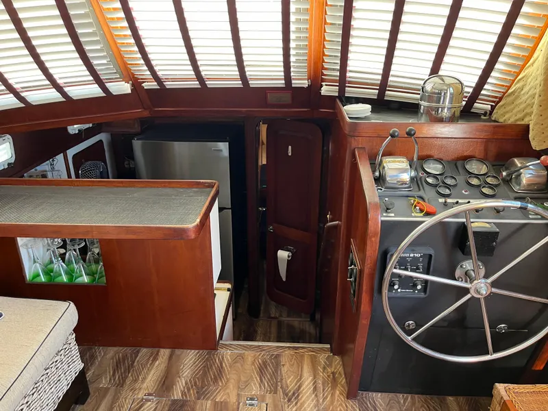 Slide: The Image of Interior of 1980 Gulfstar Trawler with helm, wooden accents, and modern appliances. - 10