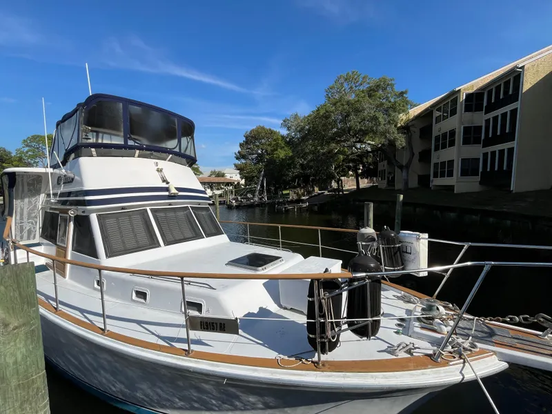 The Image of 1980 Gulfstar Trawler docked near waterfront buildings under clear blue sky. - 2