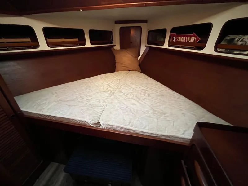 Slide: The Image of 1980 Gulfstar Trawler cabin interior with cozy bed and wooden finish. - 21