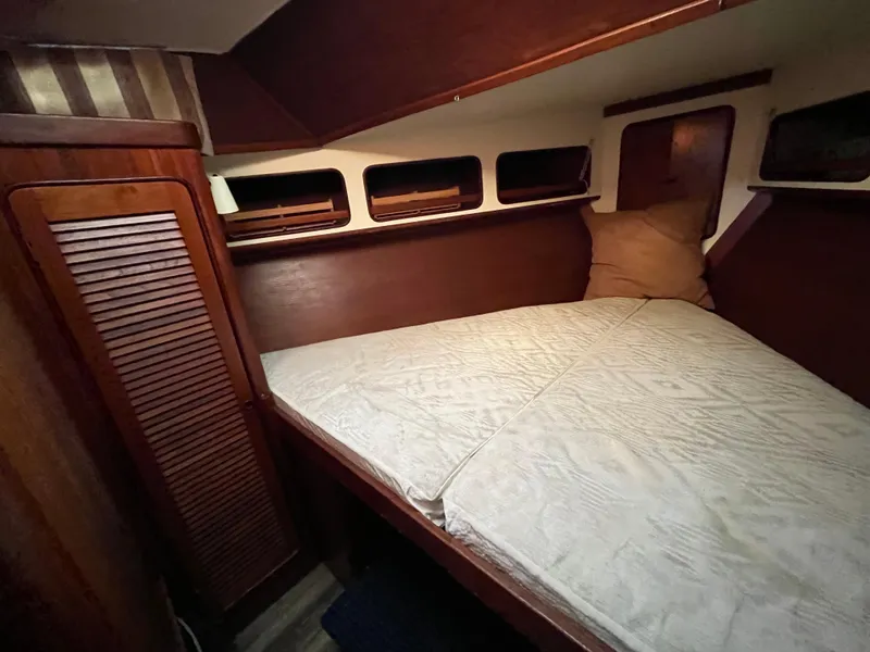 Slide: The Image of Cozy cabin interior of 1980 Gulfstar Trawler with wooden accents and comfortable bedding. - 22