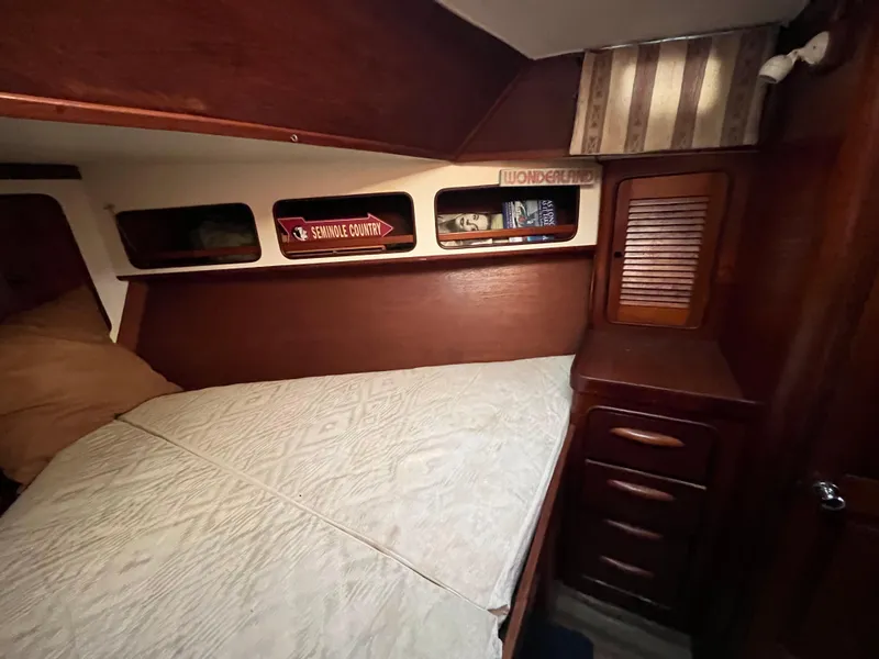 Slide: The Image of 1980 Gulfstar Trawler cabin interior with wooden furnishings and cozy bed. - 23
