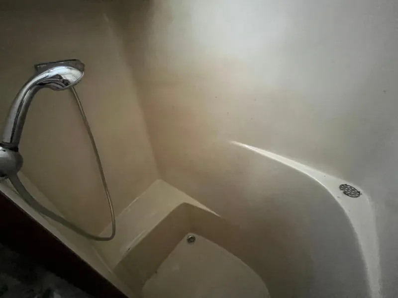 Slide: The Image of Shower area inside a 1980 Gulfstar Trawler boat, featuring a handheld showerhead. - 26