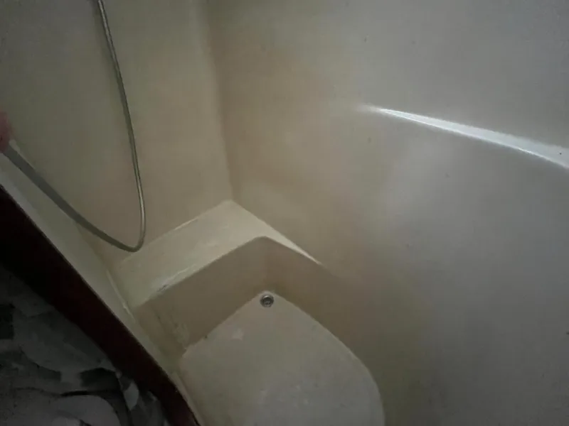 Slide: The Image of Shower area inside a 1980 Gulfstar Trawler boat, featuring a simple design. - 28