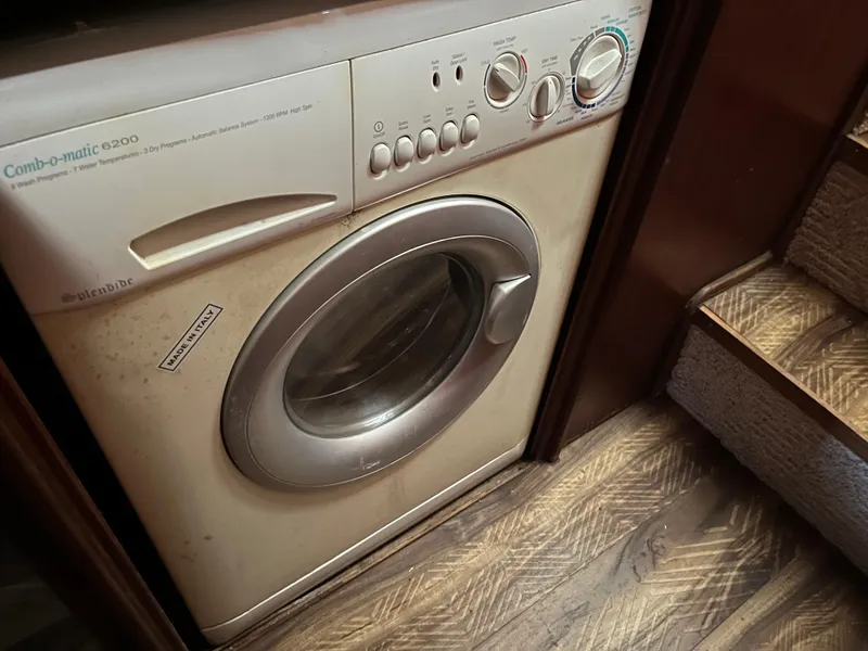 Slide: The Image of Washing machine inside a 1980 Gulfstar Trawler, next to wooden stairs. - 35