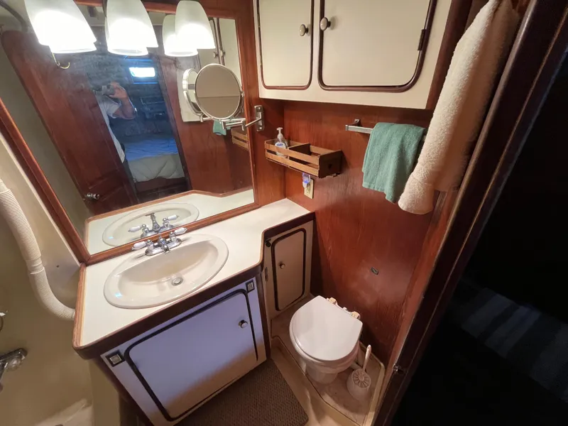 Slide: The Image of 1980 Gulfstar Trawler bathroom with sink, mirror, and wooden cabinetry. - 40