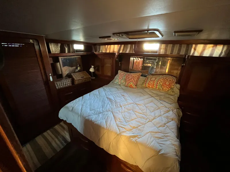 Slide: The Image of Cozy bedroom interior of 1980 Gulfstar Trawler with wood paneling and comfortable bedding. - 42