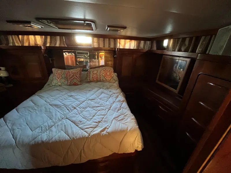 Slide: The Image of Cozy bedroom interior of a 1980 Gulfstar Trawler with wood paneling and a comfortable bed. - 43