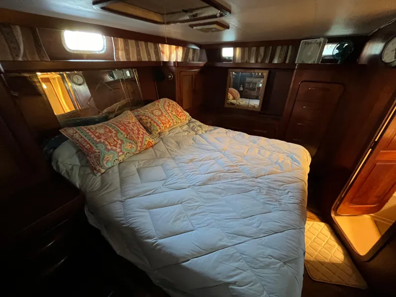 Slide: The Image of 1980 Gulfstar Trawler bedroom with cozy bedding and warm lighting. - 47