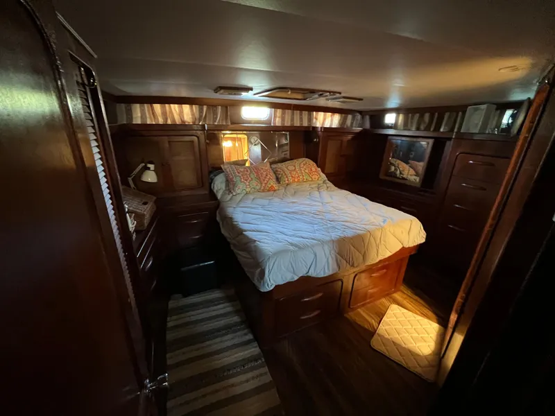 Slide: The Image of Cozy bedroom in 1980 Gulfstar Trawler with wood paneling and a comfortable bed. - 48