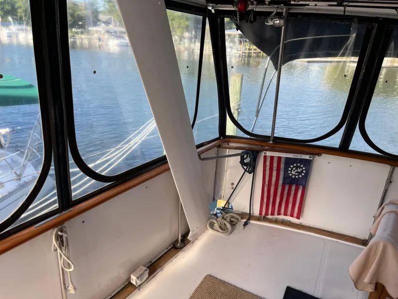 Slide: The Image of 1980 Gulfstar Trawler interior with windows, nautical decor, and marina view. - 49