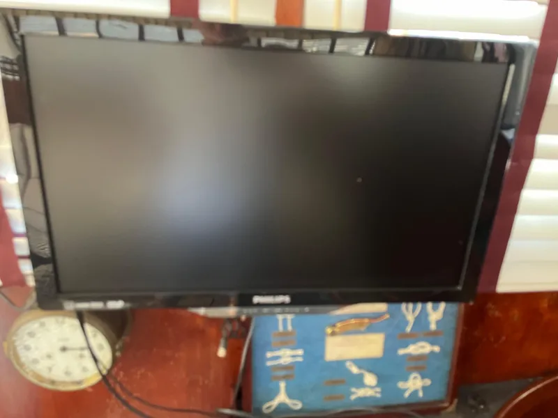 Slide: The Image of Philips monitor on a Gulfstar 1980 Trawler, with a clock and nautical decor. - 8