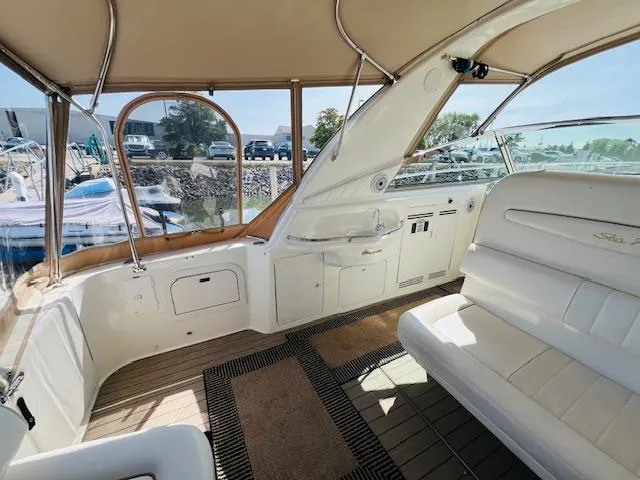 Slide: The Image of 1999 Sea Ray 400 Sundancer yacht interior with white seating and wood accents. - 12