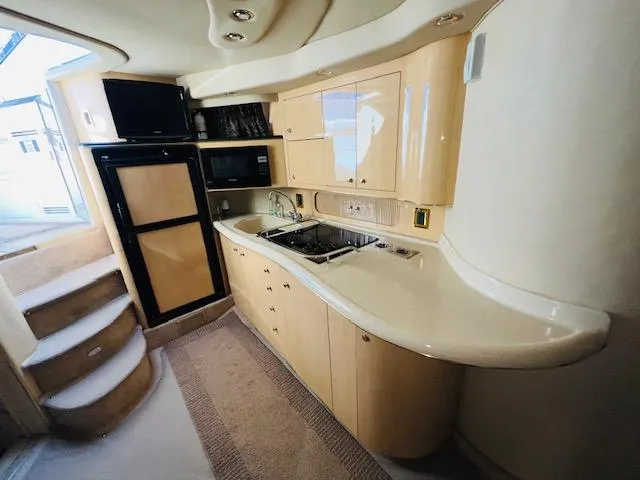 Slide: The Image of 1999 Sea Ray 400 Sundancer yacht kitchen with modern appliances and sleek cabinetry. - 17