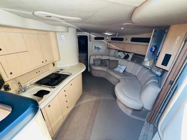 Slide: The Image of Interior of 1999 Sea Ray 400 Sundancer yacht with kitchen and curved seating area. - 21
