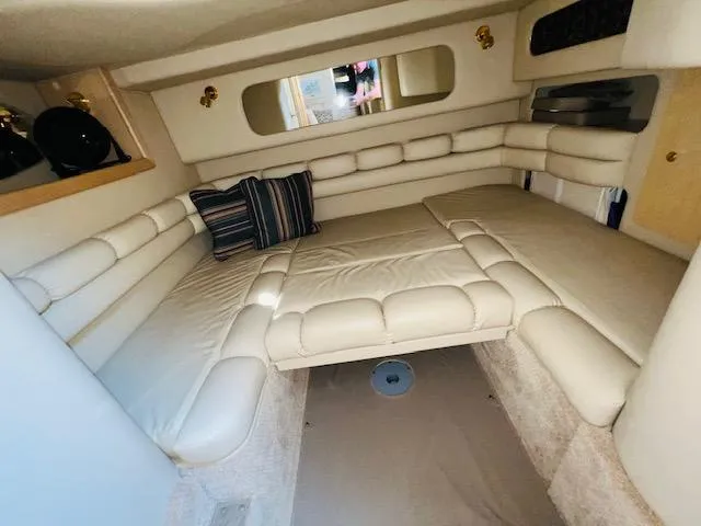 Slide: The Image of 1999 Sea Ray 400 Sundancer cabin interior with plush seating and striped pillows. - 22