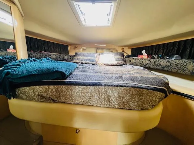 Slide: The Image of 1999 Sea Ray 400 Sundancer cabin with bed, skylight, and elegant decor. - 25
