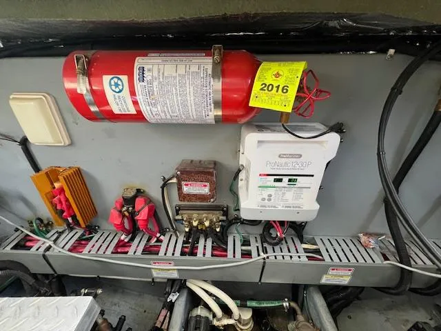 Slide: The Image of Engine room of 1999 Sea Ray 400 Sundancer with fire extinguisher and electrical components. - 33