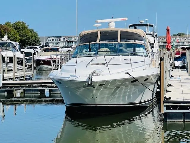 Slide: The Image of 1999 Sea Ray 400 Sundancer yacht docked at marina, clear sky, calm water. - 4