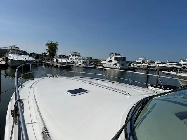 Slide: The Image of 1999 Sea Ray 400 Sundancer yacht docked in a marina under clear blue skies. - 5