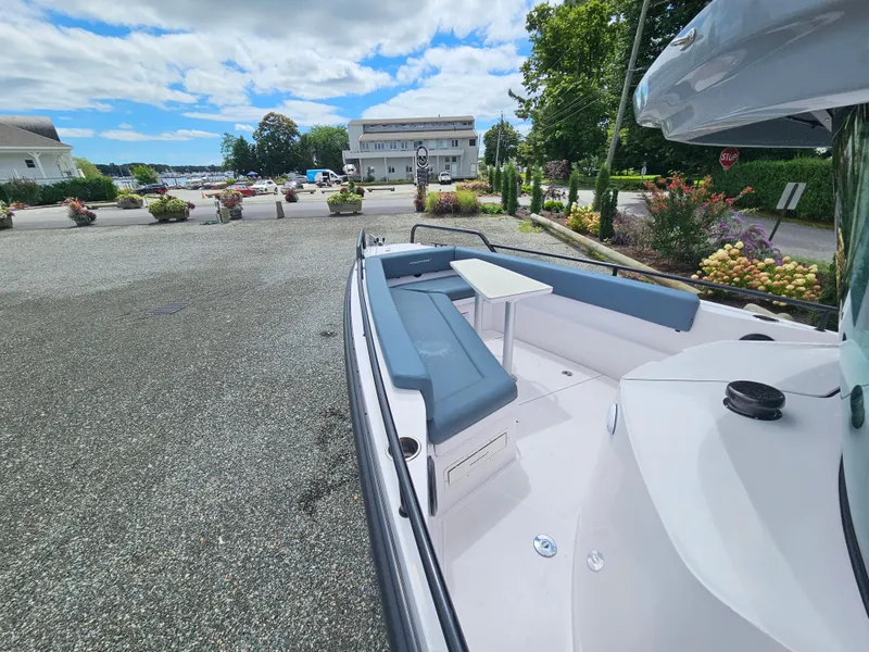 Slide: The Image of 2022 Axopar 28 boat with seating area, docked near a waterfront building. - 13