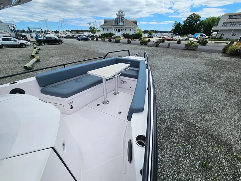 Slide: The Image of 2022 Axopar 28 boat with seating area and table, docked in a marina. - 14