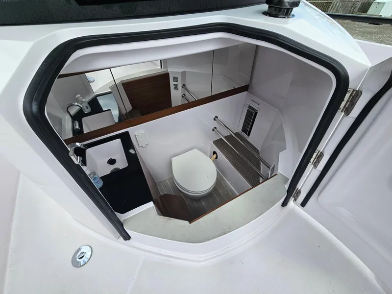 Slide: The Image of 2022 Axopar 28 boat interior bathroom with sink, toilet, and mirror. - 16