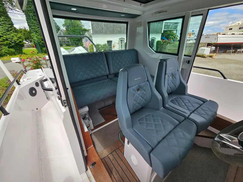 Slide: The Image of 2022 Axopar 28 boat interior with blue quilted seating and modern design. - 19