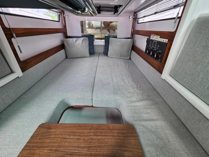 Slide: The Image of Interior cabin of 2022 Axopar 28 boat with gray seating and wooden accents. - 20
