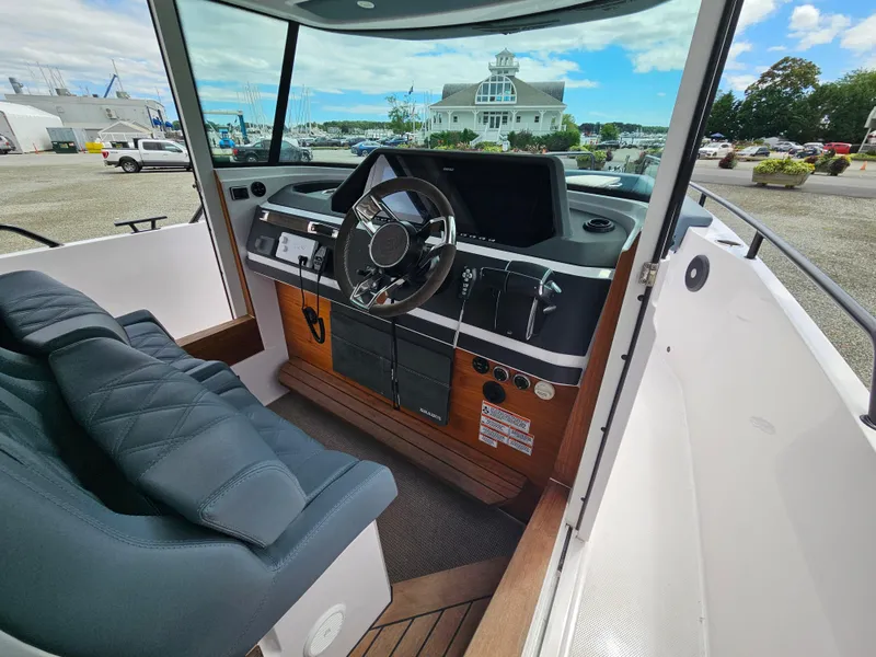 Slide: The Image of 2022 Axopar 28 boat interior with steering wheel and dashboard. - 21