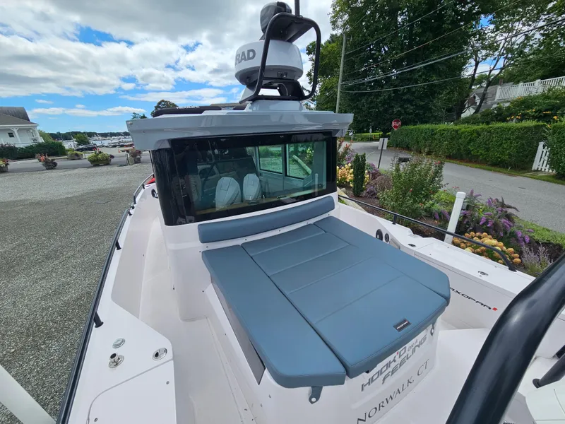 Slide: The Image of 2022 Axopar 28 boat with radar, docked in a scenic marina setting. - 9