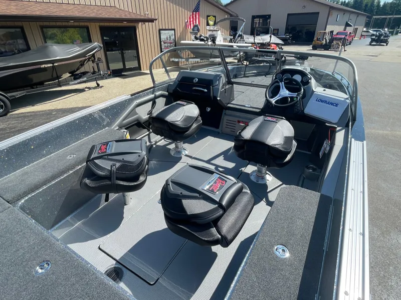 Slide: The Image of 2025 Ranger 620FS boat interior with seating and steering console, parked outdoors. - 6
